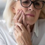 Close,Up,60,Years,Old,Unhappy,Businesswoman,Having,Toothache,Holding