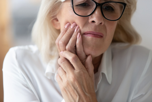 Close,Up,60,Years,Old,Unhappy,Businesswoman,Having,Toothache,Holding