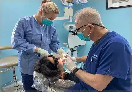 Dr. Roberto Russo performing a dental procedure with an assistant in an operatory at R&S Dental Associates in Clifton, NJ.