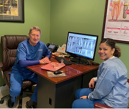 El Dr. Mike Shulman y una asistente dental revisan radiografías digitales en el monitor de una computadora en R&S Dental Associates, en Clifton, Nueva Jersey.
